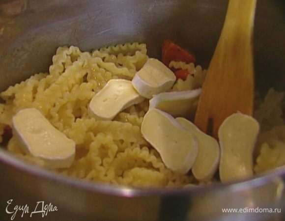 Добавить сыр, влить немного воды, в которой варились макароны, перемешать. 