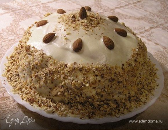 Весь торт обмазать кремом, обсыпать дроблеными орехами и украсить целым миндалем.