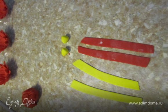 Делаем из желтой мастики шарики. Раскативаем красную и желтую мастику и вырезаем полоски по 0,5 см.