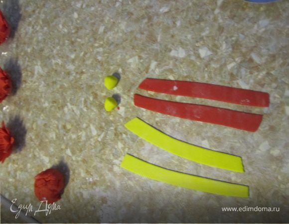 Делаем из желтой мастики шарики.
Раскативаем красную и желтую мастику и вырезаем полоски по 0,5 см.