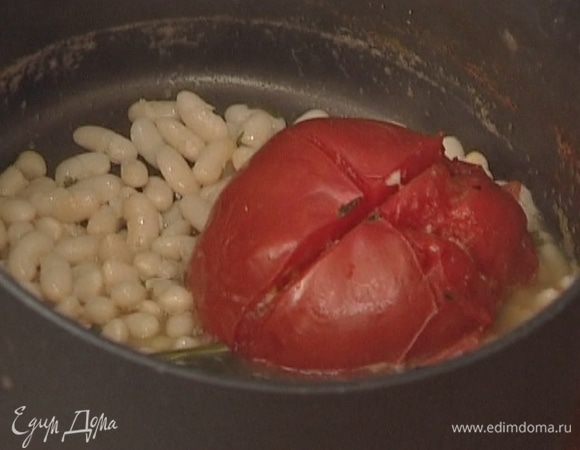 Вынуть из кастрюли с фасолью помидор, чеснок и петрушку.