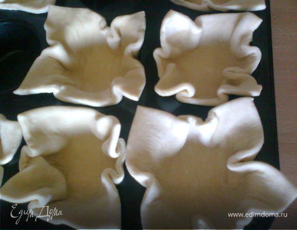 Предварительно размораживаем тесто.Тесто разрезаем на квадраты и стелем в формы для маффинов.