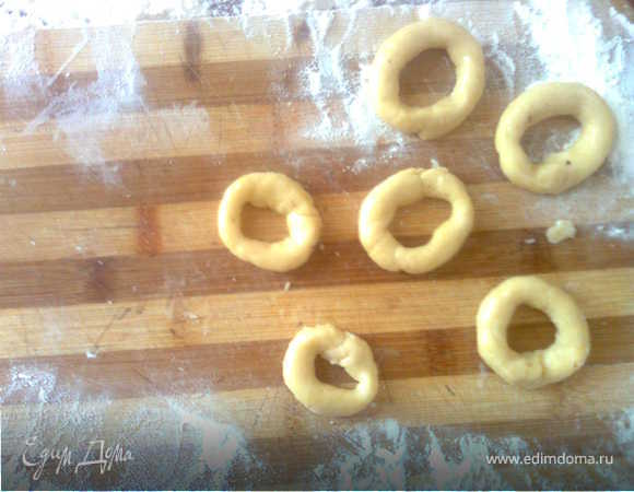 Смазываем бублики белком, обмакиваем одной стороной в сахар, смешанный с измельченными орехами.