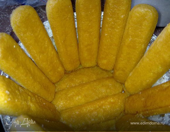 Пока яблоки готовятся, выкладываем форму.
Главное - нам надо яблоки плотно запечатать! Хорошо поливаем приготовленным сиропом савоярди. Смотрите, если они у вас очень рассыпчатые и начнут разваливаться при намокании (попробуйте на одном печении), окунайте их в сироп непосредственно перед выкладкой в форму. Выкладываем печенье (в сиропе) максимально плотно и аккуратно. Не оставляя свободных мест вообще. Вначале - донышко. Затем, стенки.
