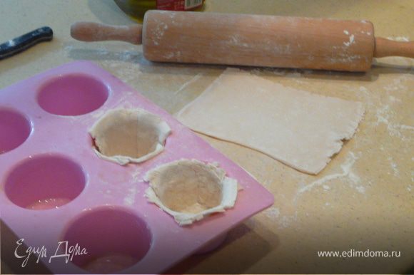 Смазать формы для маффинов, нарезать тесто на квадраты и выложить в каждую форму. Наполнить фаршем и накрыть тестом сверху. Смазать яйцом или молоком сверху и печь при 180С 25 минут.