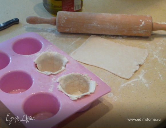 Смазать формы для маффинов, нарезать тесто на квадраты и выложить в каждую форму. Наполнить фаршем и накрыть тестом сверху. Смазать яйцом или молоком сверху и печь при 180С 25 минут.