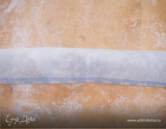 Когда тесто увеличиться, раскатать его, подсыпав немного муки в лепешку.
Смочить немного поверхность и скатать плотным рулетом.
