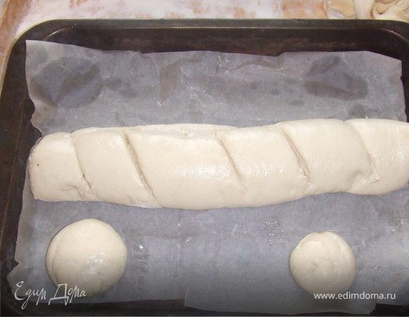 Перед выпечкой на батоне в середине делаем два неглубоких надреза. Сбрызгиваем буханку водой.