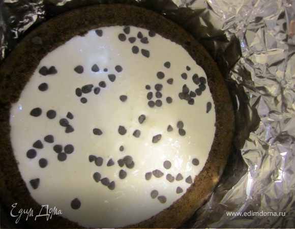 Половину крема вылить в нашу форму, посыпать черным шоколадом, накрыть генуэзским бисквитом.
Сверху ставимеще один бортик, выливаем остатки крема и посыпаем белым шоколадом. Закрываем коржом Шоколада на кипятке.
Торт ставим на ночь в хородильник.