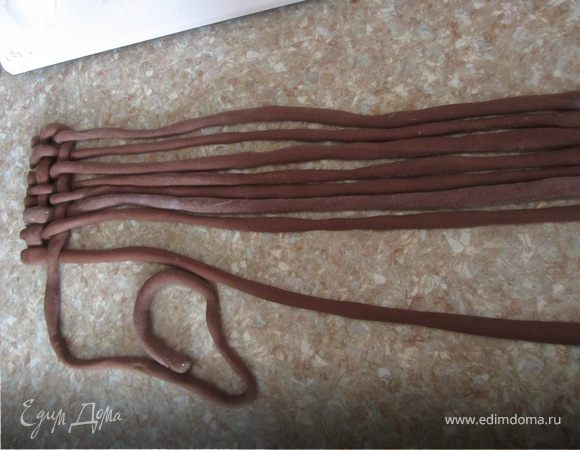 Из шоколадной мастики раскатываем длинные жгутики, примерно в 1,2 больше по обхвату нашего тортика.
И начинаем корзино плетение.