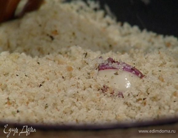 Разогреть в небольшой сковороде 2 ст. ложки масла, добавить оставшиеся зубчики чеснока, хлебные крошки и все вместе обжарить. 