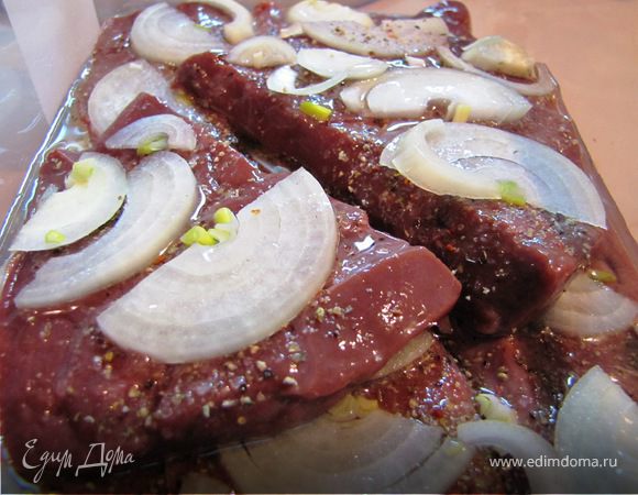 Печень солим, перчим, складываем в судочек, посыпаем луком, поливаем растительный маслом