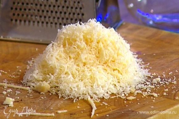 Желтки слегка взбить вилкой и соединить с большей частью натертого сыра.