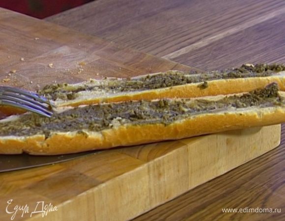 Багет разрезать вдоль пополам, намазать обе половинки тапенадом и дать ему немного впитаться. 
