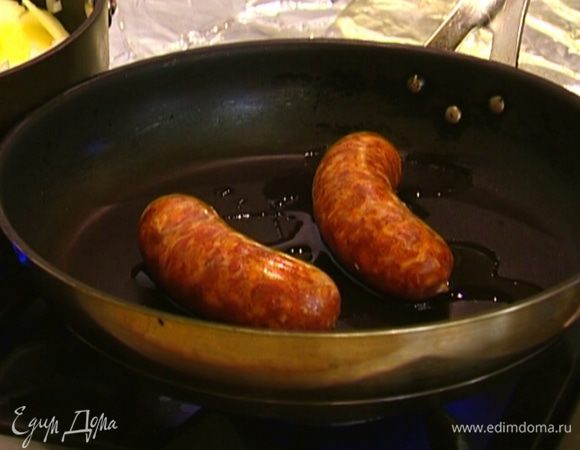 В другой сковороде разогреть оставшееся оливковое масло и обжаривать колбаски 6–8 минут, до готовности.