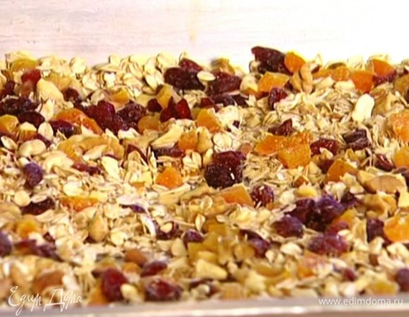 Выложить овсянку и ореховую смесь на противень, перемешать, полить кленовым сиропом и равномерно распределить.