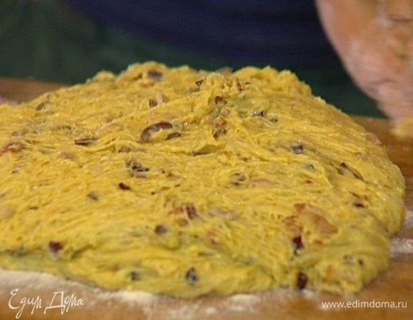 Присыпать рабочую поверхность мукой, выложить тесто и немного его обмять.