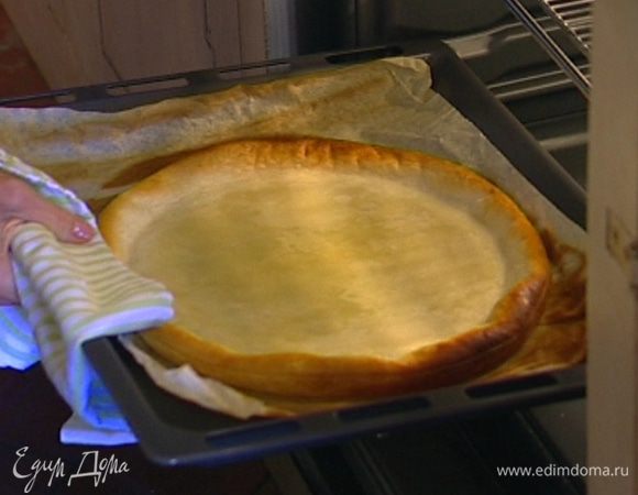 Слоеное тесто раскатать, выложить на противень, застеленный бумагой для выпечки, сверху накрыть еще одним листом бумаги для выпечки, засыпать горохом и отправить на 20 минут в разогретую духовку, затем снять бумагу с горохом и выпекать еще пару минут.