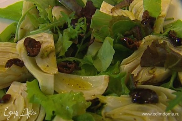 Листья салата выложить на тарелку, сверху разложить фенхель, полить половиной заправки с оливками.