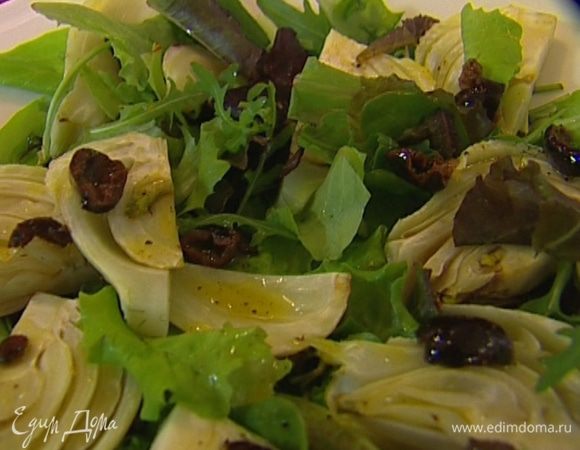 Листья салата выложить на тарелку, сверху разложить фенхель, полить половиной заправки с оливками.