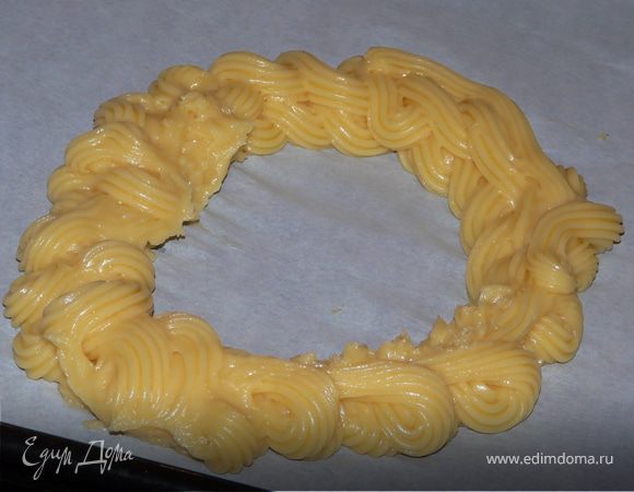 При помощи кондитерского мешка на деко, застеленное бумагой выдавить тесто в форме кольца (15-20см), посыпать миндальной стружкой.