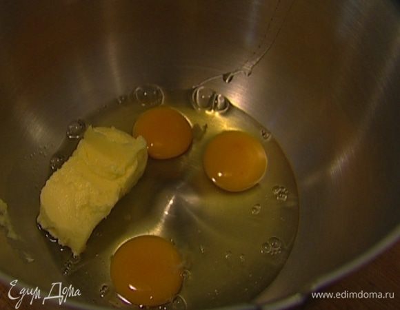 Приготовить тесто: предварительно размягченное сливочное масло и яйца взбить с оставшимся сахаром и бренди. 