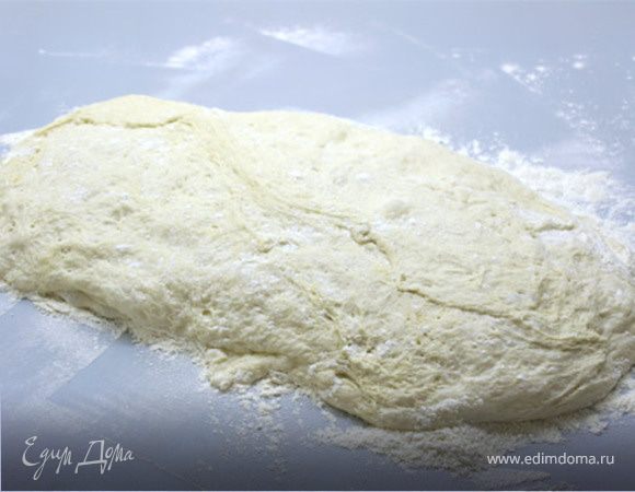 Вылейте тесто, на хорошо посыпанную мукой рабочую поверхность.