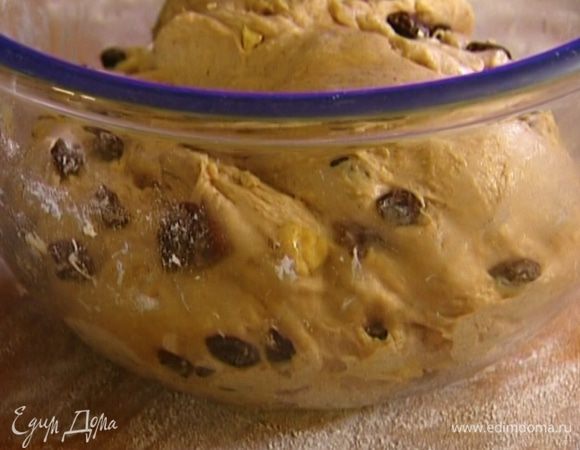 Высыпать на разделочную доску оставшуюся муку, обвалять в ней изюм и орехи и вмешать их в тесто.