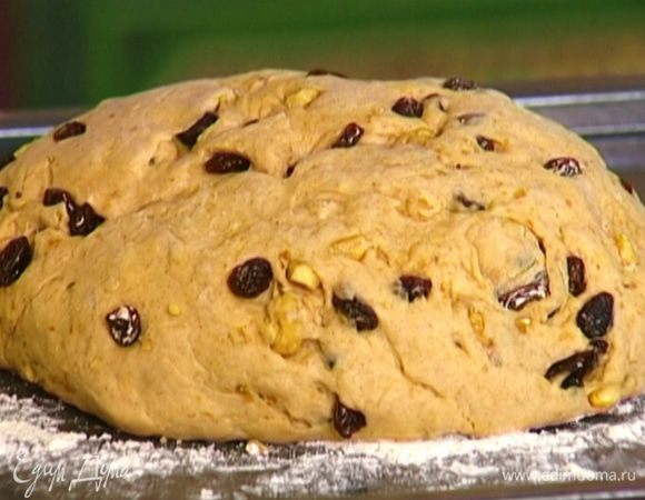 Противень присыпать мукой. Сделать из теста шар, выложить на противень и немного прижать руками, придав ему форму каравая, накрыть полотенцем и оставить на 10 минут.