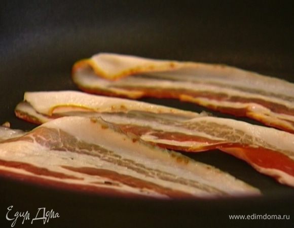 Бекон обжарить с двух сторон на сухой сковороде и выложить на бумажное полотенце, чтобы убрать излишки жира, затем поместить на нижнюю половинку булочки.