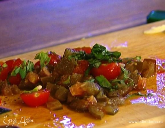 К нарезанным кубиками помидорам добавить базилик, чеснок, посолить, поперчить и перемешать.