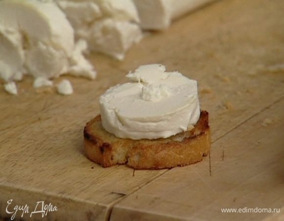 Козий сыр нарезать кружками, разложить на обжаренный хлеб и поставить в духовку под гриль на 8−10 минут.