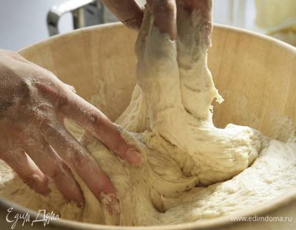 Посыпать стол мукой, выложить на него тесто и вымесить его руками.