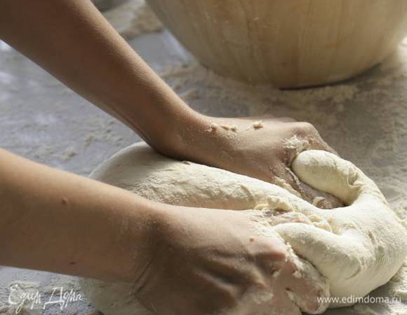 Через час выложить тесто на стол, присыпанный мукой, и сделать второй замес.