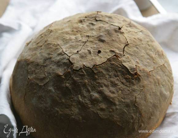 Присыпать мукой противень, выложить на него тесто, сформировав из него круглый хлеб, выпекать 10 минут в разогретой духовке. Затем убавить нагрев до 220°С и выпекать еще 30 минут.