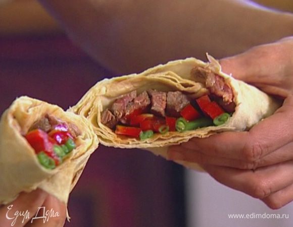 На лист лаваша выложить фасоль, сладкий перец, говядину и свернуть конвертиком, а затем разрезать наискосок пополам, чтобы получилось два ролла.