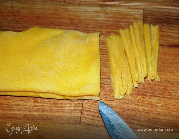 Нарежьте лапшу острым ножом. Все то же самое повторите с остальными тремя частями теста.