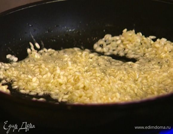 Растопить в сковороде сливочное масло, всыпать рис и дать ему пропитаться маслом.