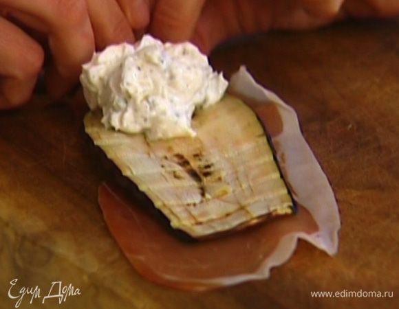 На каждый ломтик ветчины уложить полоску баклажана, а сверху — творожную начинку, свернуть в рулетики.