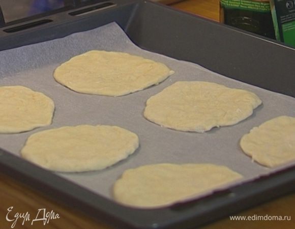 Отрывая от теста небольшие кусочки, из каждого сформировать небольшую лепешку, стараясь делать ее как можно тоньше, и выложить на застланный бумагой для выпечки противень. Накрыть полотенцем и оставить на 30 минут.
