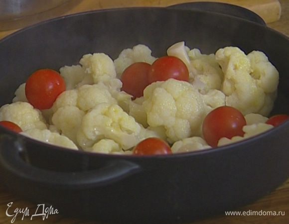 Капусту слить, выложить в тяжелую жаропрочную форму, сбрызнуть оливковым маслом, добавить помидоры черри целиком и отправить на 15 минут в духовку, а затем на 5 минут под гриль.