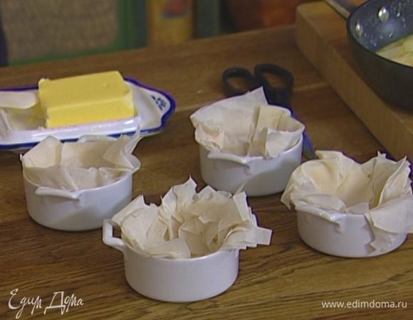 Выстелить огнеупорные керамические формочки тестом фило так, чтобы края немного свешивались.