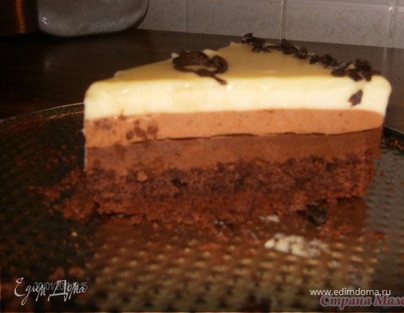 ПРИГОТОВЛЕНИЕ МУСС:
Готовим 3 вида мусса:
 Замочить желатин в холодных сливках (на 24 гр желатина 50 гр сливок) – это количество - на 3 мусса. Сливки (охлажденные) 600 гр - взбить до «крепких пиков» - разделить взбитую массу на 3 равные части (по 200 гр на каждый вид мусса) поставить в холодильник.
 
Шоколад черный разломать на кусочки и нагреть со сливочным маслом, при постоянном помешивании, на маленьком огне, до полного расплавления шоколада. Затем добавить набухший желатин и снова прогреть, не доводя до кипения, до полного расплавления желатина. Влить сливочный ликер, перемешать. Оставить немного остыть. Затем, соединить взбитые сливки с шоколадной массой, аккуратно перемешивая. Достаем наш бисквит из морозилки. Форму изнутри прокладываем прозрачной плотной пленкой – выше бортиков формы не менее чем на 5-7 см. Выкладываем на бисквит сверху и в зазор между бисквитом и формой - черный шоколадный мусс – разравниваем лопаточкой и снова ставим в морозилку
 
. Таким же образом готовим мусс из молочного шоколада – и выкладываем его поверх черного мусса.
 
Последним готовим мусс из белого шоколада – и выкладываем на мусс из молочного шоколада. Наш торт-заготовка почти готов – ставим его на ночь в холодильник – чтобы желатин хорошо застыл. (Или, если нет времени. оставляем на 30 мин в морозилке).
 