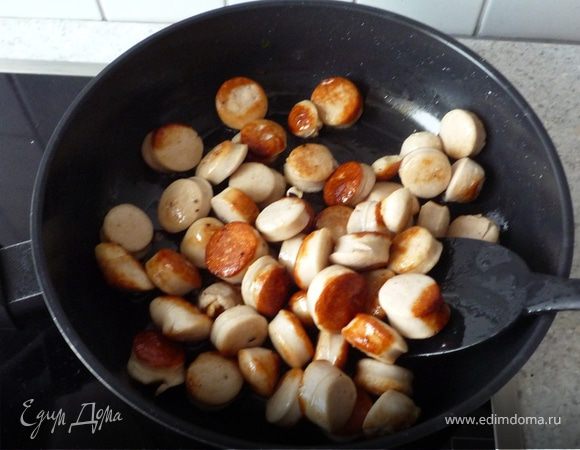 Колбаски нарезать небольшими кусочками и обжарить до корочки на раст. масле.