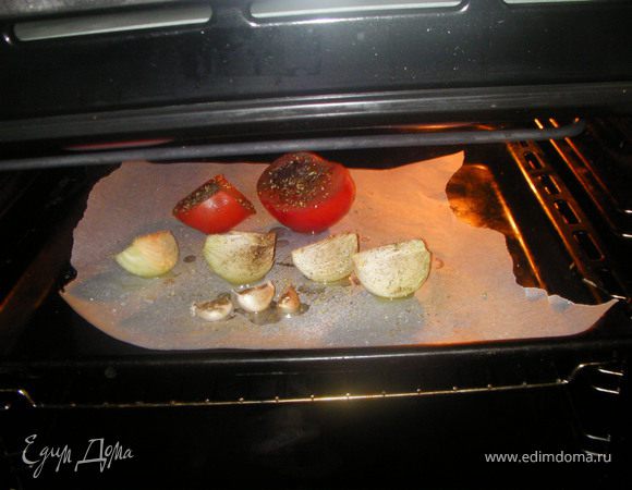 Для приготовления заправки разрежь помидоры пополам,очищенную луковицу-на 4 части.Выложи овощи на противень вместе с неочищенными зубчиками чеснока.Сбрызни растительным маслом, посоли,поперчи и посыпь базиликом.Запекаем овощи для соуса в духовке 45 мин. при Т=180С.