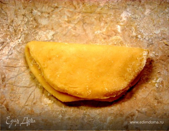 Кружок намазываем растопленным и охлажденным сливочным маслом, посыпаем сахаром и сворачиваем вдвое…