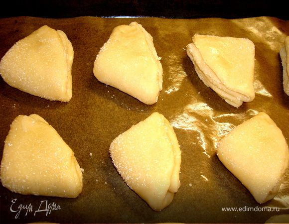 Верх печенья смазываем маслом последний раз и посыпаем сахаром. Выкладываем наше печенье на пергамент, смазанный сливочным маслом…