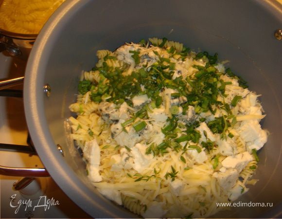 Быстро вернуть пасту обратно в кастрюлю, добавить лук, листики тимьяна, все четыре сыра и перемешать, сыры должны начать плавиться