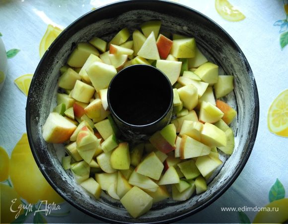 Форму смазать маслом, посыпать мукой и положить в нее нарезанные яблоки. 