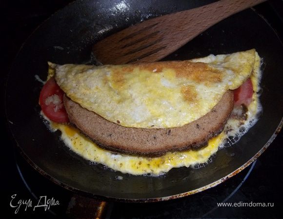 Сверху наркрыть свободной половиной омлета и жарить еще 2-3мин. до готовности